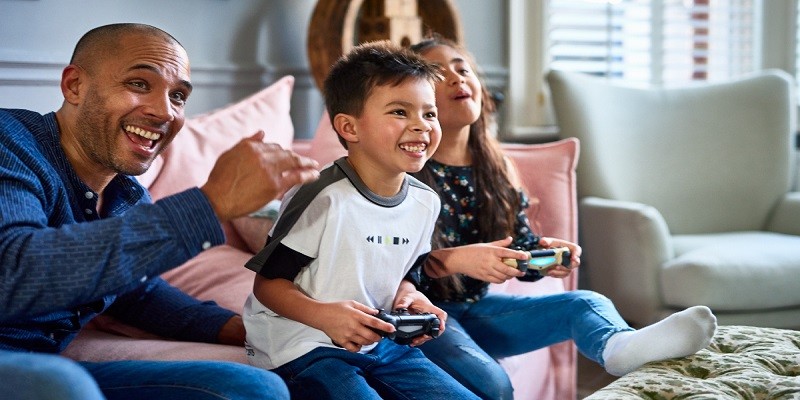 Excited father watching son and daughter play video game Why Is Epic Games Asking For Parental Permission